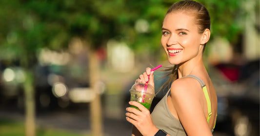 Smiling woman drinking a protein shake outdoors, demonstrating how to use protein powder for weight loss.