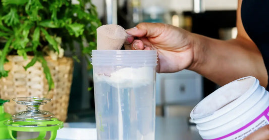 A hand pouring vegan protein powder, demonstrating how to use plant protein powder.