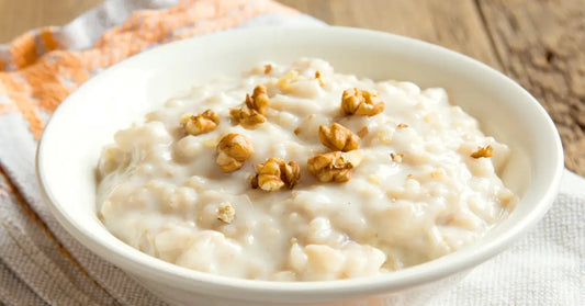 Bowl of oatmeal topped with walnuts, illustrating the addition of protein powder to oatmeal.