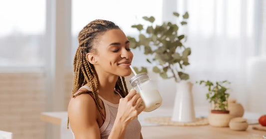 A woman enjoying a protein shake, exploring ways on how to make protein powder taste better for a satisfying experience.