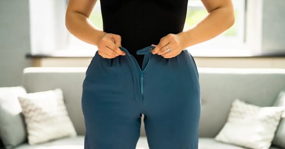 Person adjusting their pants to demonstrate weight gain achieved through using protein powder for weight gain.