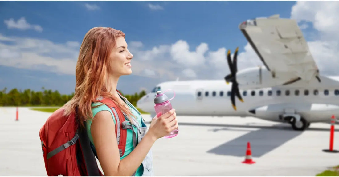 Smiling woman with a backpack and water bottle at the airport, representing the question can you bring protein powder on a plane.