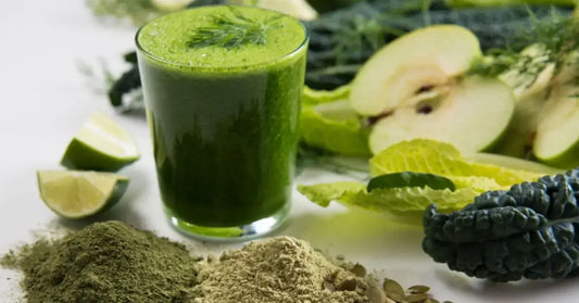 A glass of green plant-based protein shake surrounded by its natural ingredients, hinting at its easy digestibility.